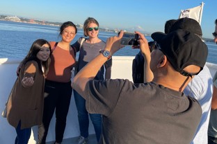 Students pose on a boat excursion during a Quantic Conference.